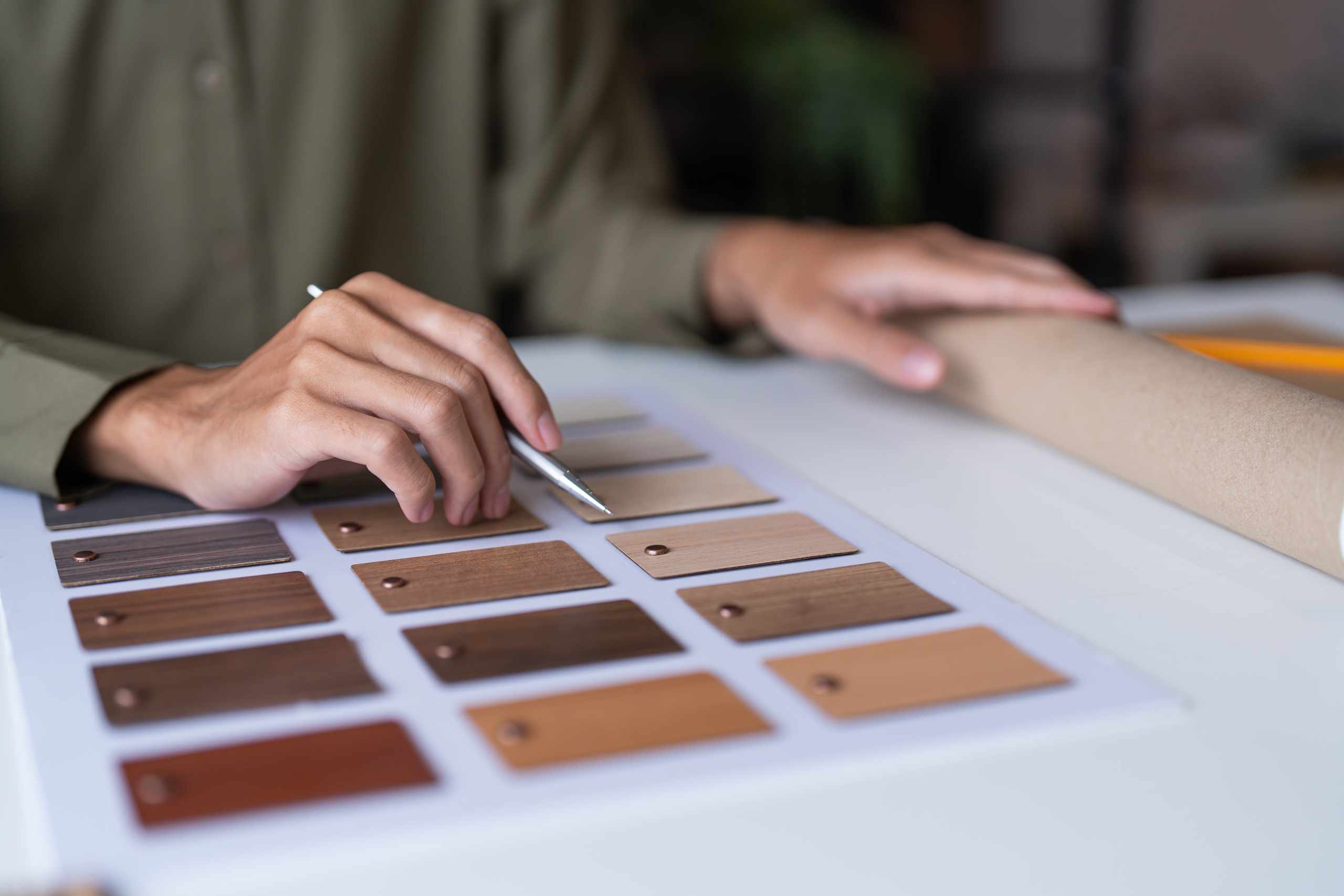 Hands selecting wood material samples